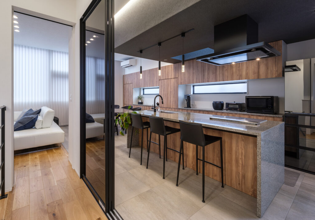 黒の下がり天井と木目が美しい千葉県の注文住宅キッチン。アイランド型で家族とのコミュニケーションも円滑に。