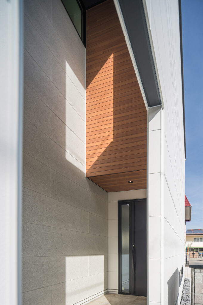 千葉県の注文住宅にふさわしい、木目天井が映えるおしゃれな玄関アプローチ。雨に濡れない動線設計。